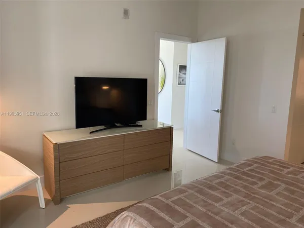 a bedroom with a bed and a flat screen tv