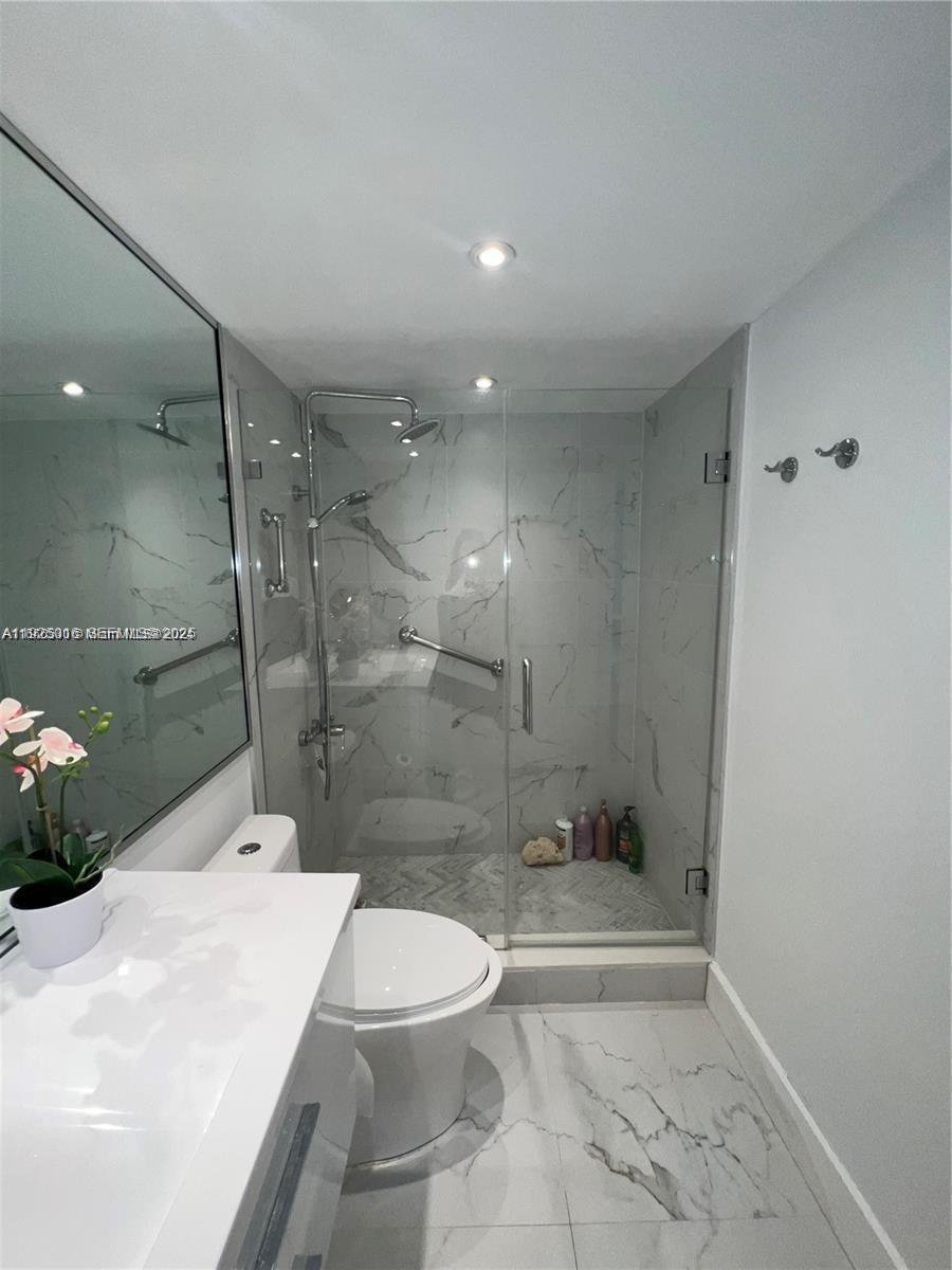 5555 Collins Avenue, Unit 7T Miami Beach, FL 33140 - Photo 15 of 19 a bathroom with a shower and a toilet