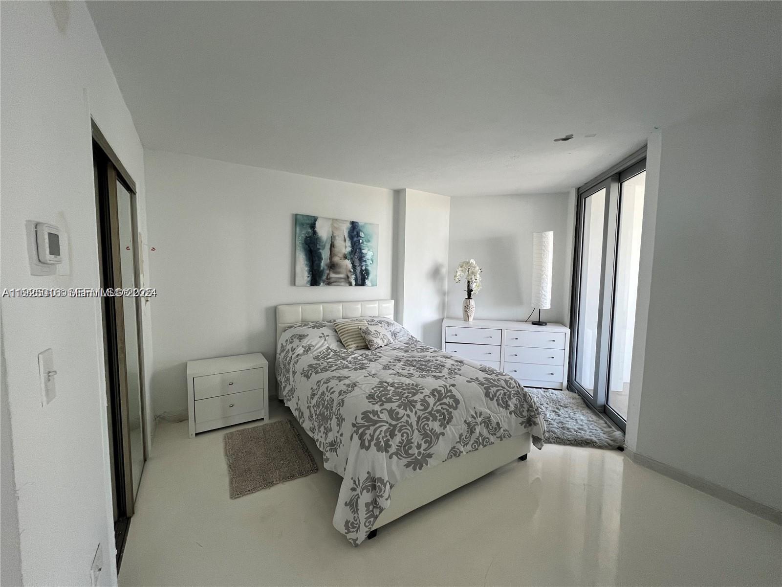 5555 Collins Avenue, Unit 7T Miami Beach, FL 33140 - Photo 16 of 19 a bedroom with a bed and a painting on the wall