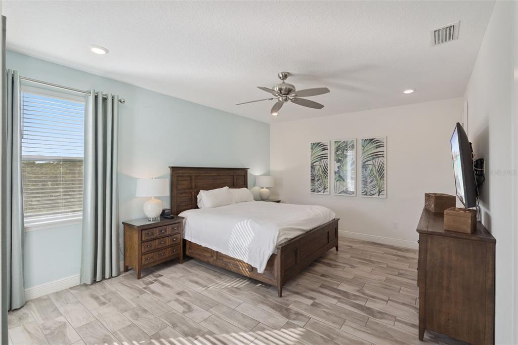 8082 Knee Deep Road Kissimmee, FL 34747 - Photo 16 of 30 a bedroom with a large bed and a flat screen tv