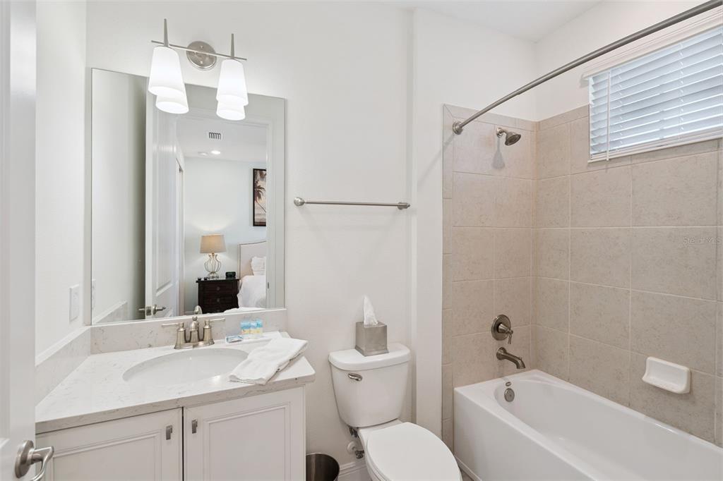 8082 Knee Deep Road Kissimmee, FL 34747 - Photo 25 of 30 a bathroom with a granite countertop sink a toilet and shower