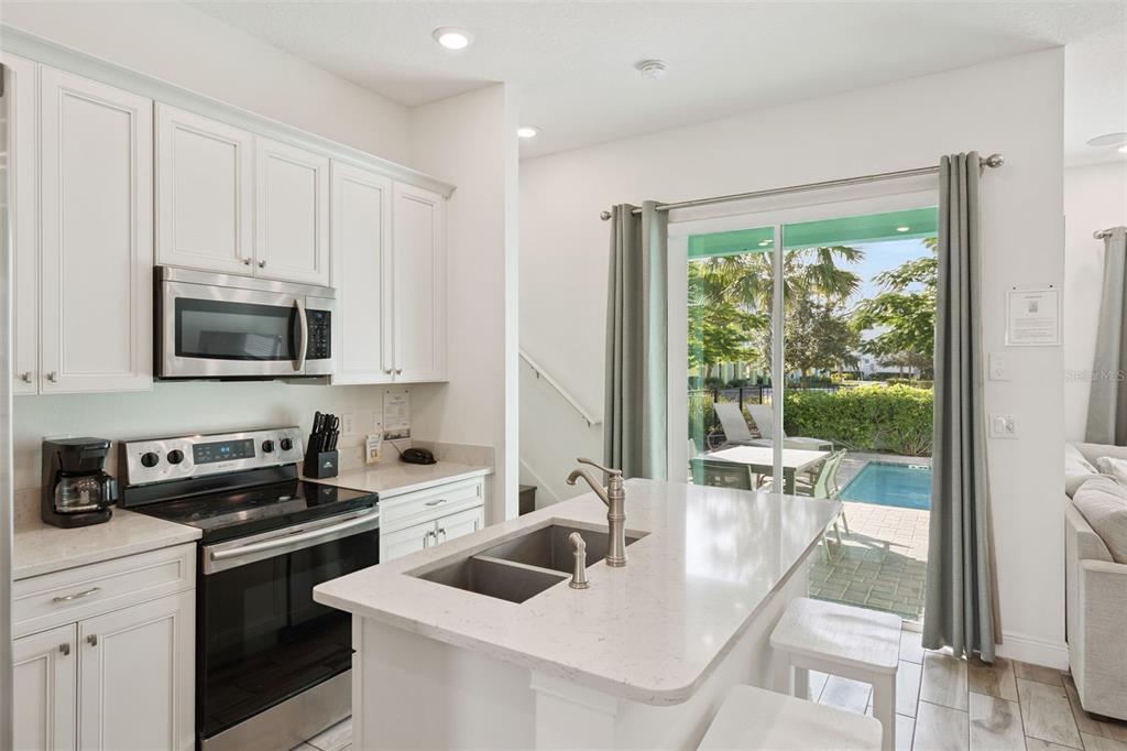 8082 Knee Deep Road Kissimmee, FL 34747 - Photo 4 of 30 a kitchen with a stove a sink and a microwave