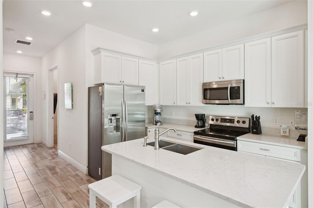 8082 Knee Deep Road Kissimmee, FL 34747 - Photo 5 of 30 a kitchen with stainless steel appliances a refrigerator stove and white cabinets