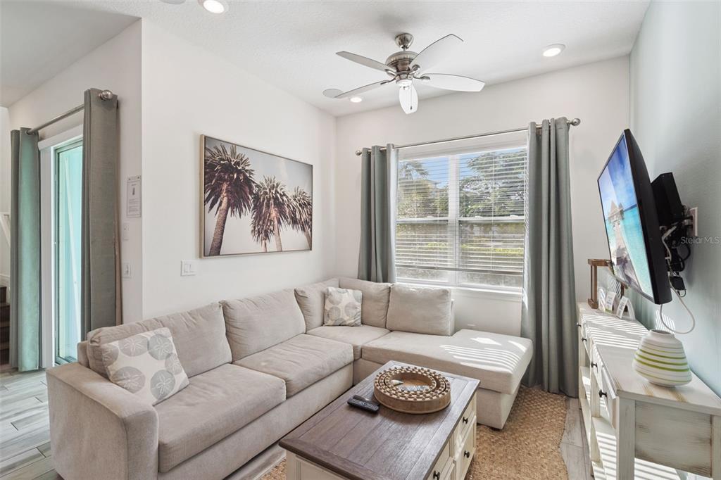 8082 Knee Deep Road Kissimmee, FL 34747 - Photo 6 of 30 a living room with furniture a flat screen tv and a large window