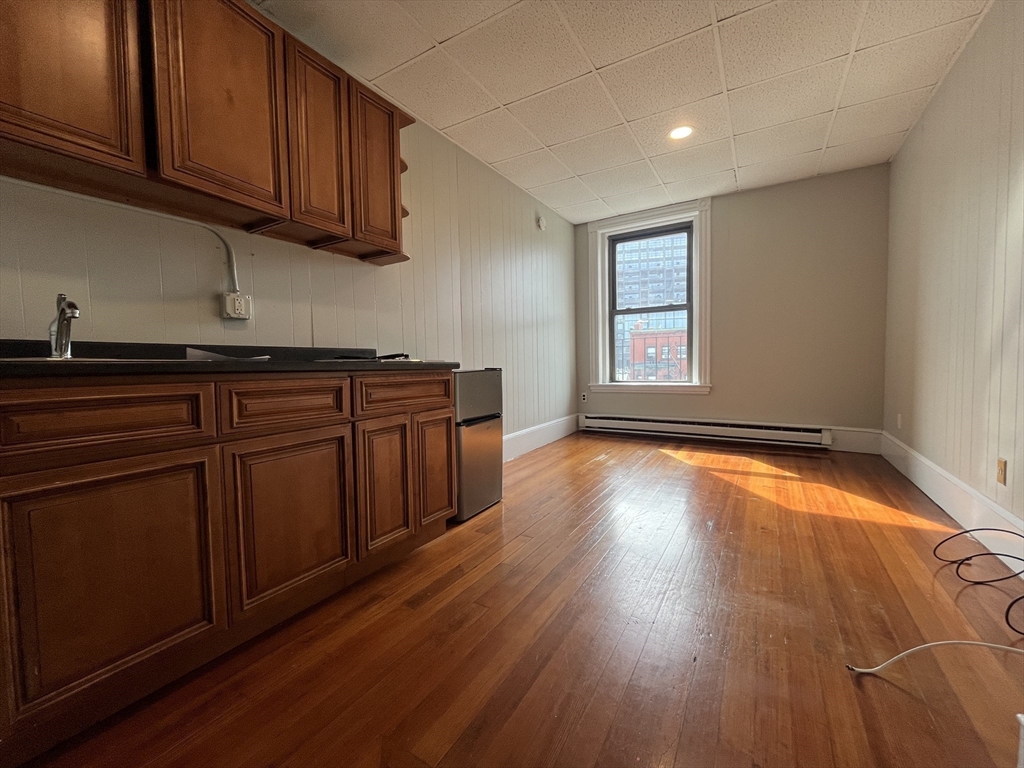 868 Beacon Street, Unit 14 Boston, MA 02215 - Photo 4 of 5 a view of a kitchen with wooden floor and cabinets