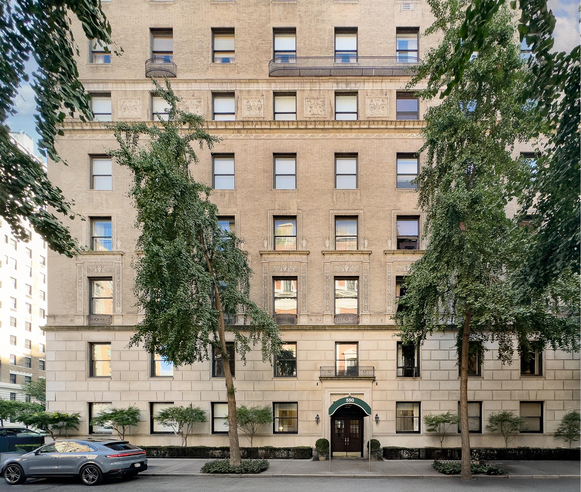 550 Park Avenue, Unit 12E Manhattan, NY 10065 - Photo 26 of 29 a front view of a building with lot of cars and trees
