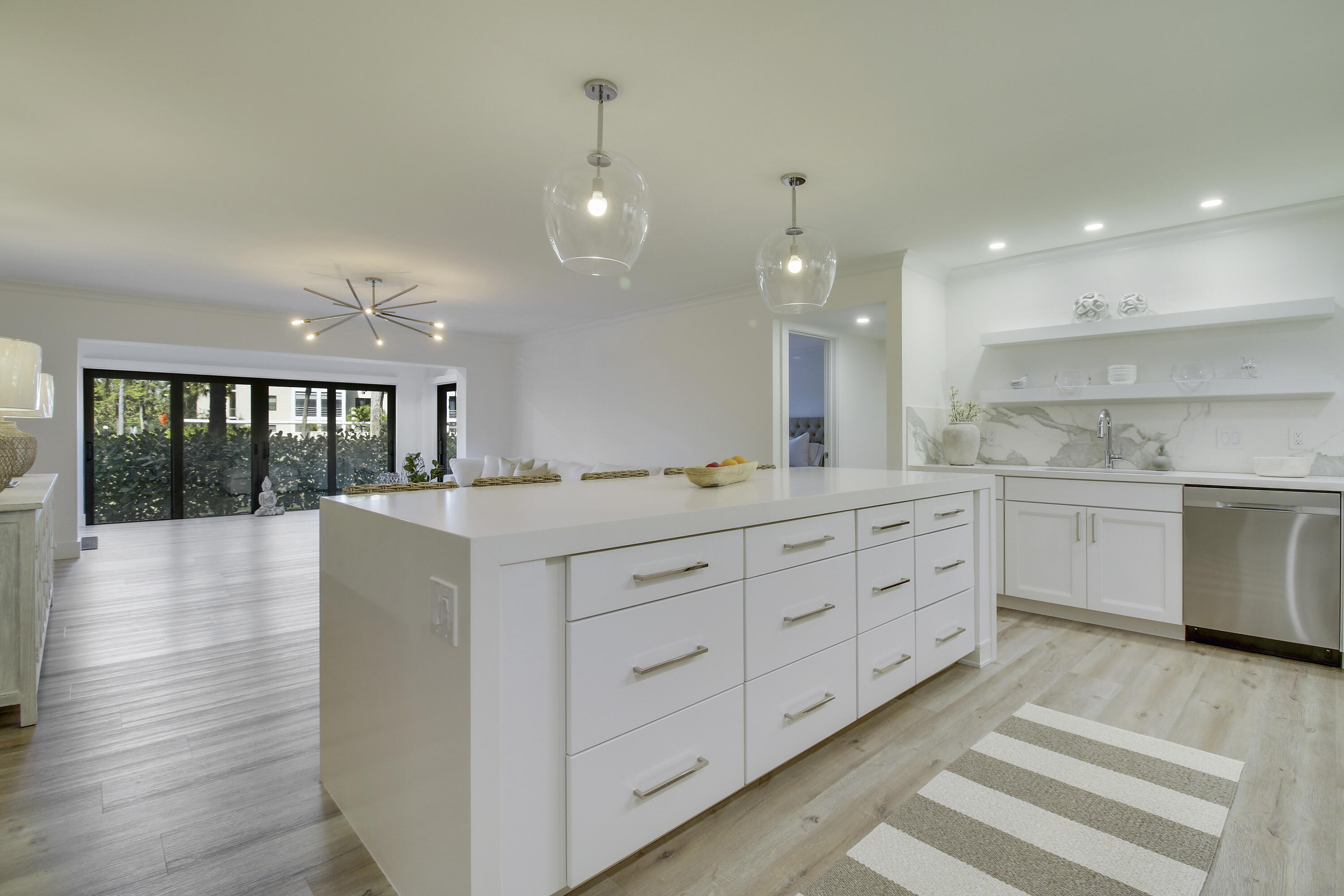 a large white kitchen with a large window a oven and white cabinets