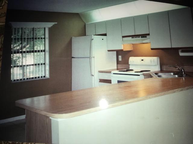 1400 Northwest 45th Street, Unit B5 Pompano Beach, FL 33064 - Photo 5 of 9 a kitchen with a refrigerator and a stove