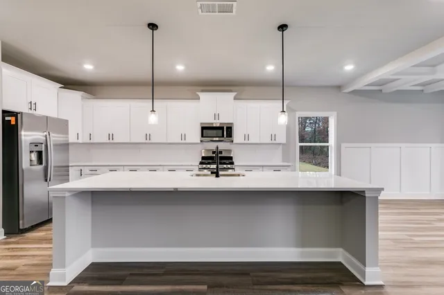a kitchen with kitchen island a sink stainless steel appliances and cabinets