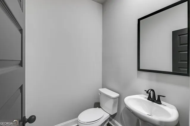 a white toilet sitting next to a bathroom sink