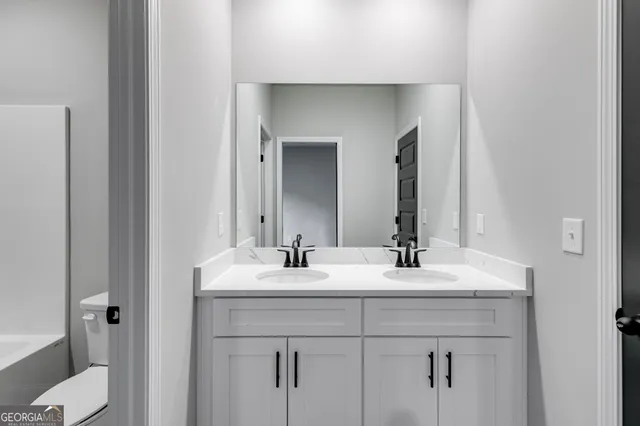 a bathroom with a sink and a mirror with toilet