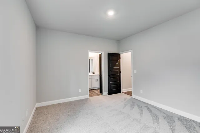 a view of an empty room with closet and entryway