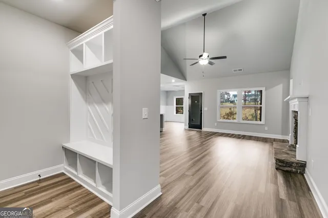 a view interior of a house with wooden floor a ceiling fan and windows