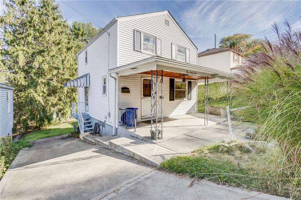 a view of a white house with a patio and a yard