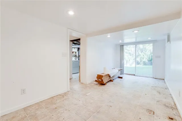 an empty room with window and a couch