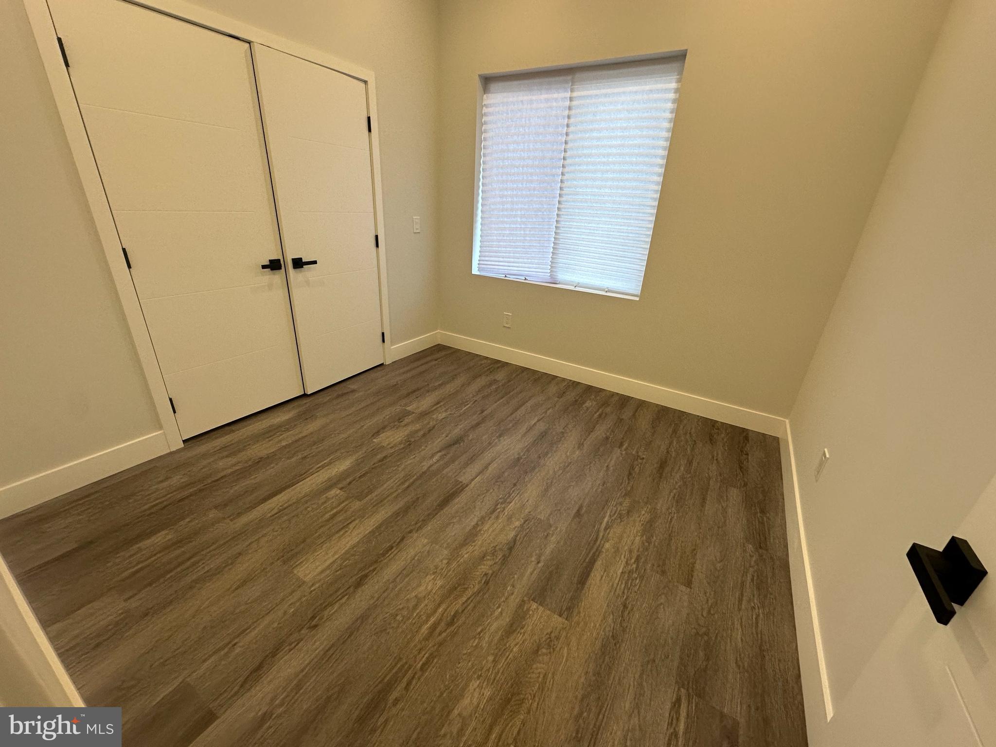 2120 North 7th Street, Unit 3 Philadelphia, PA 19122 - Photo 5 of 9 a view of an empty room with wooden floor and a window