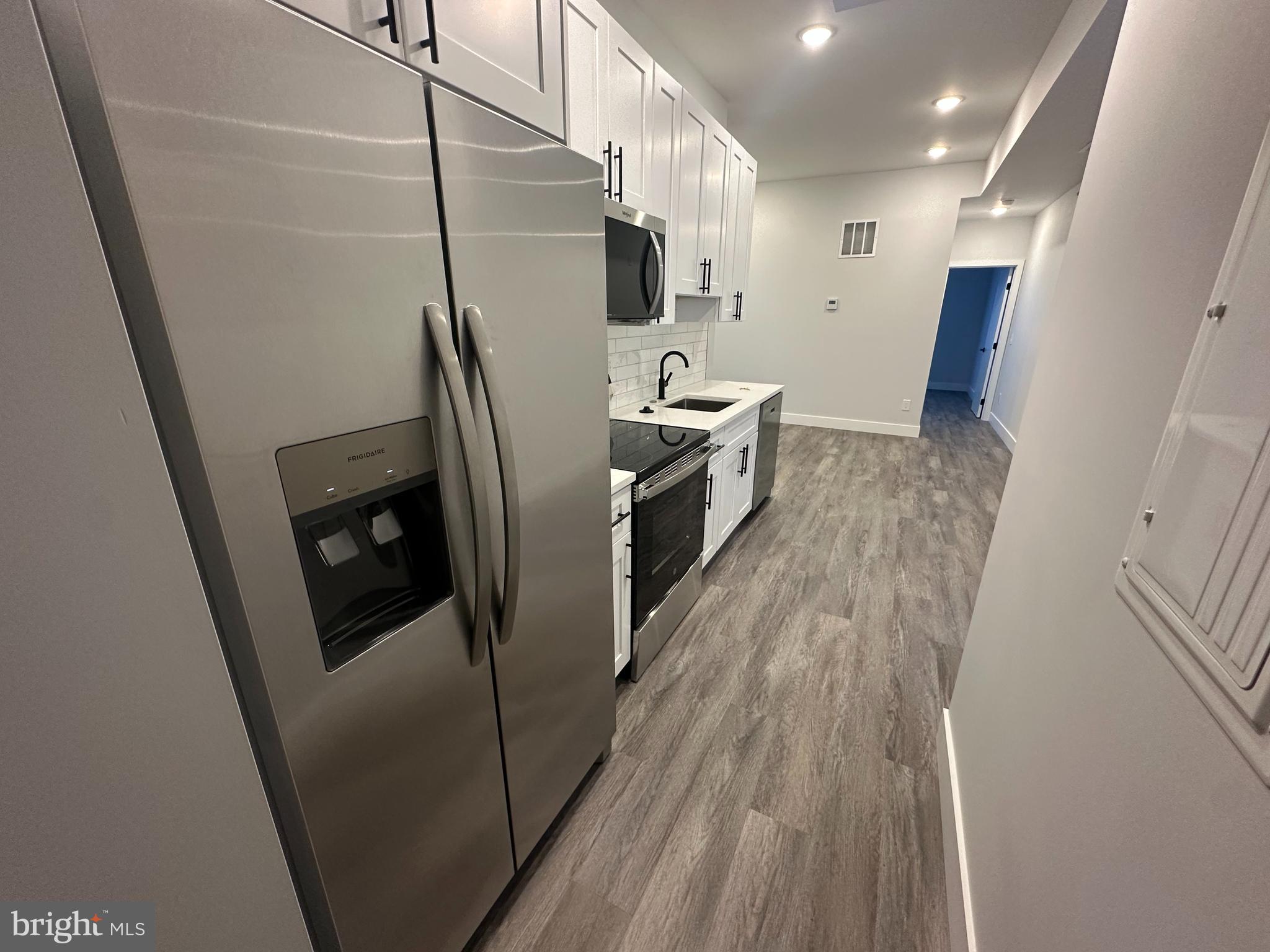 2120 North 7th Street, Unit 3 Philadelphia, PA 19122 - Photo 7 of 9 a kitchen with refrigerator a sink and wooden floor