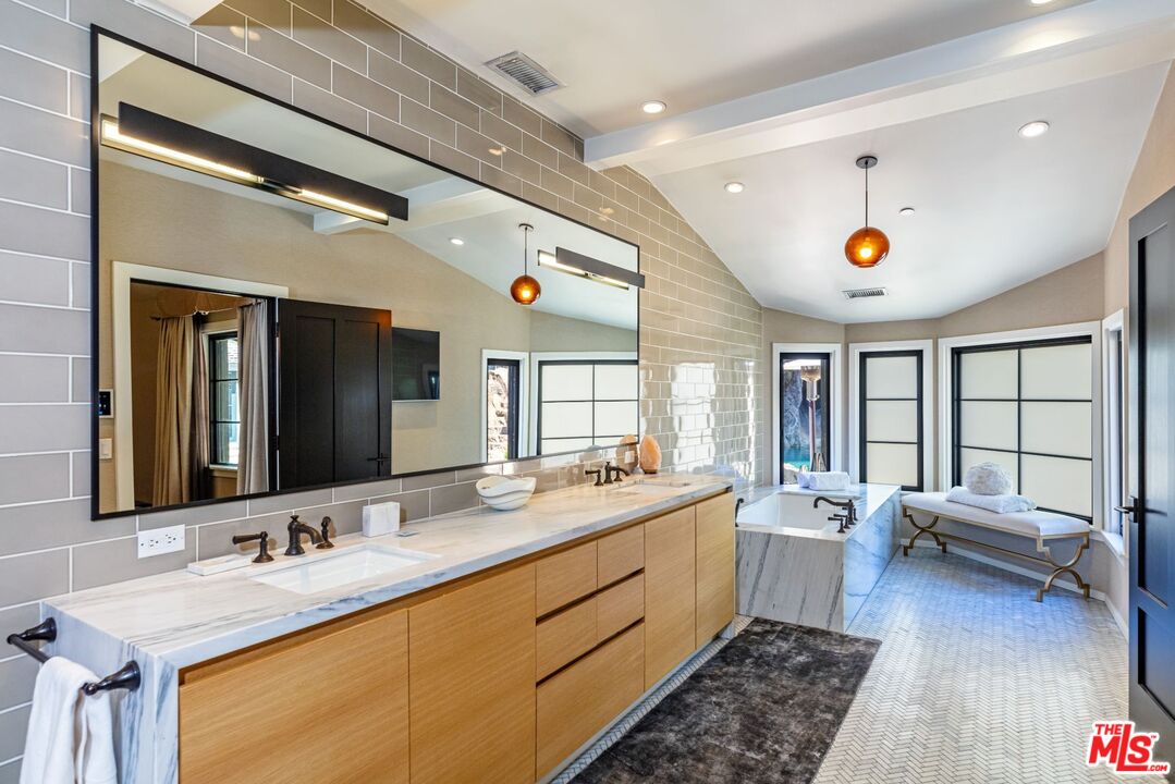 5841 Round Meadow Road Hidden Hills, CA 91302 - Photo 15 of 33 a bathroom with a sink double vanity granite tub and a large mirror