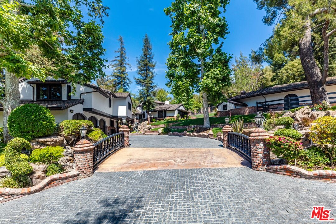 5841 Round Meadow Road Hidden Hills, CA 91302 - Photo 2 of 33 a view of a yard with plants and a table and chairs