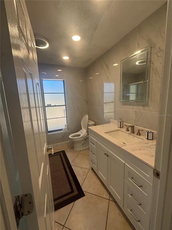 14208 Mayer Avenue Hudson, FL 34669 - Photo 16 of 29 a bathroom with a granite countertop sink a mirror and a shower