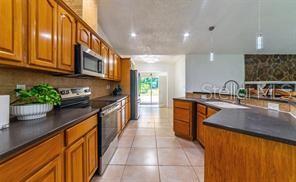 14208 Mayer Avenue Hudson, FL 34669 - Photo 4 of 29 a kitchen with stainless steel appliances granite countertop a sink counter space cabinets and a large window