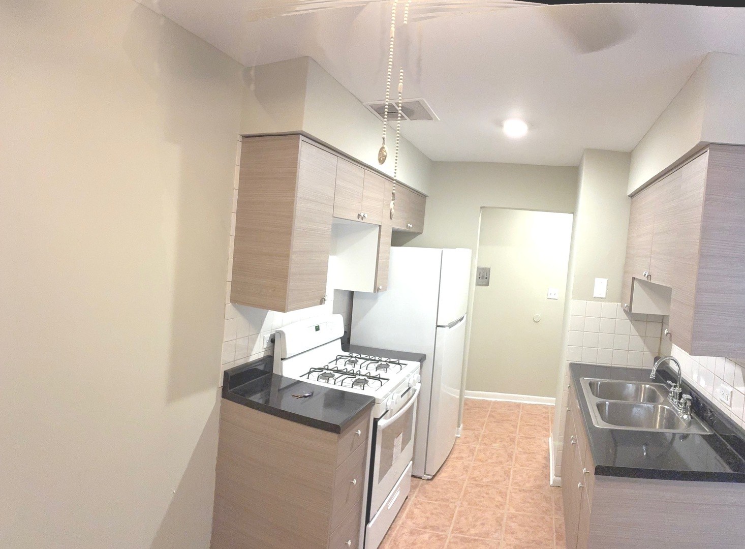 5420 North Kenmore Avenue, Unit 205 Chicago, IL 60640 - Photo 2 of 6 a kitchen with stainless steel appliances granite countertop a sink stove and refrigerator