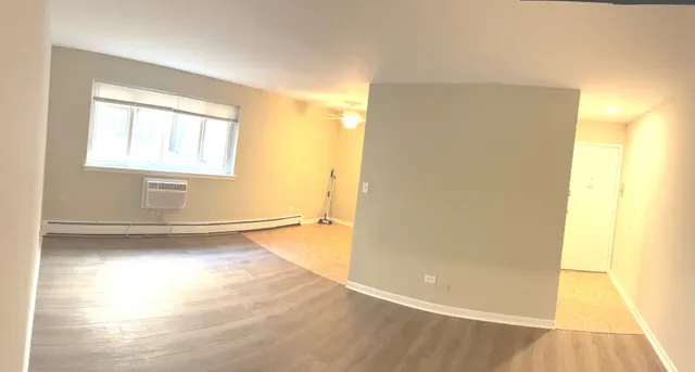 a view of a room with wooden floor and a window
