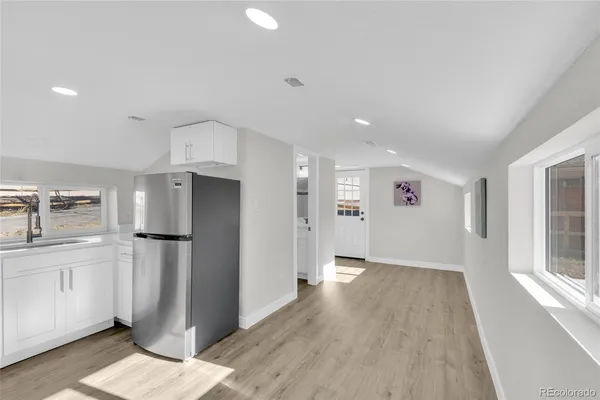 a kitchen with a sink a refrigerator and cabinets