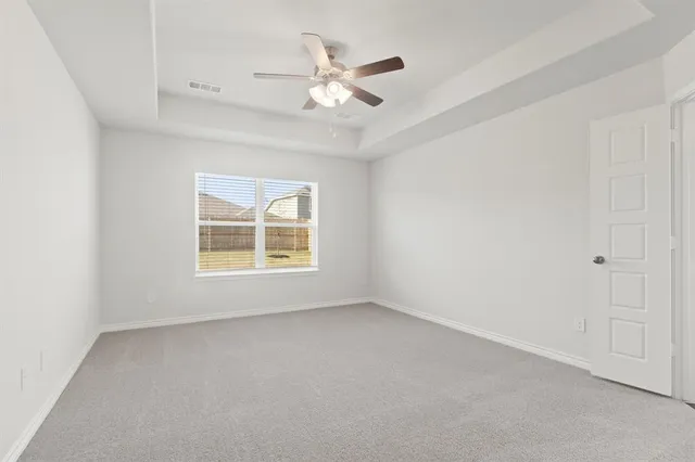 an empty room with a window and a ceiling fan