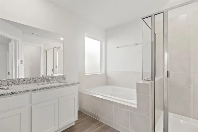 a bathroom with a granite countertop sink and a bathtub