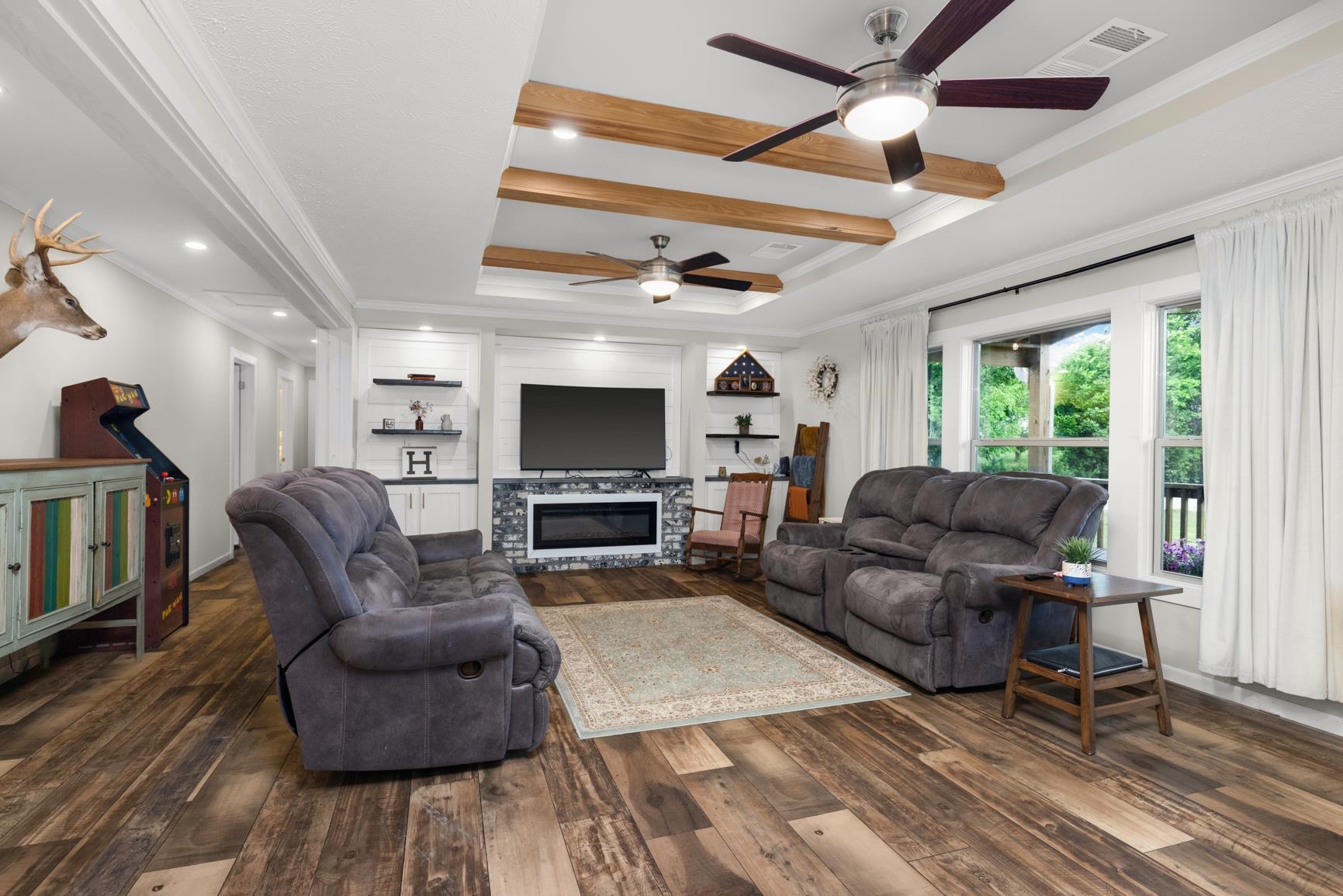 4044 Beaver Creek Road Mason, TN 38049 - Photo 12 of 36 Living area featuring ceiling fan, crown molding, hardwood / wood-style flooring, a raised ceiling, and a glass covered fireplace