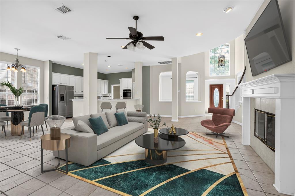 111 Ripplewood Coppell, TX 75019 - Photo 9 of 34 Spacious living area featuring tile flooring, a prominent white fireplace, and a ceiling fan