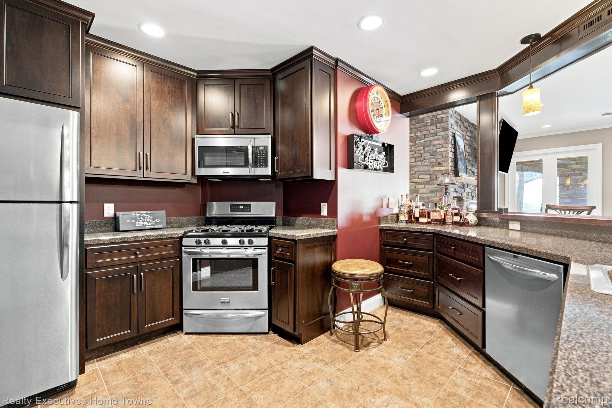 2829 Riverside Drive Port Huron, MI 48060 - Photo 43 of 99 Stainless steel appliances, recessed lighting, wood-finish cabinetry, stone counters, and tile flooring
