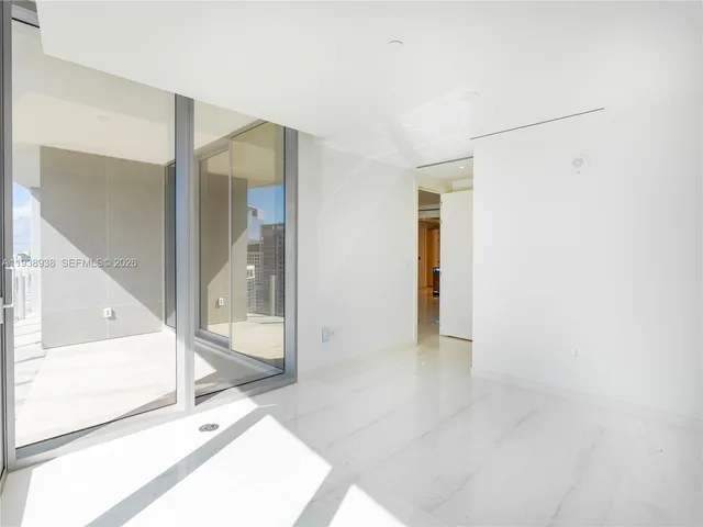 a view of a hallway with wooden floor and glass door