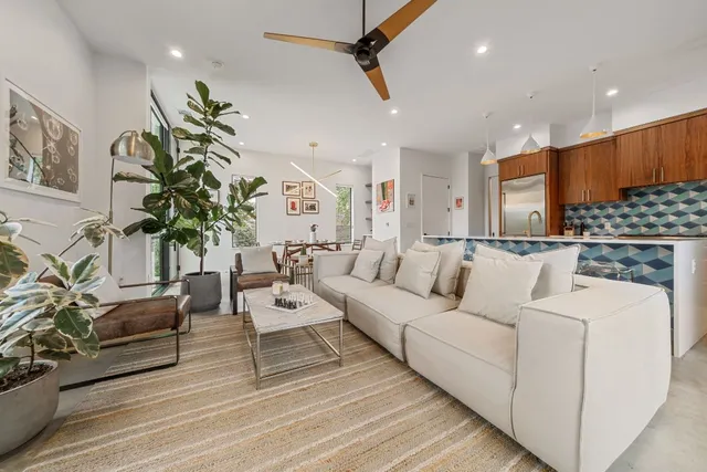 a living room with furniture kitchen and a potted plant