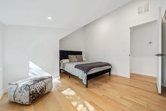 a bedroom with a bed and wooden floor