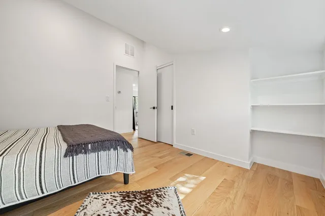 a bedroom with a bed and wooden floor