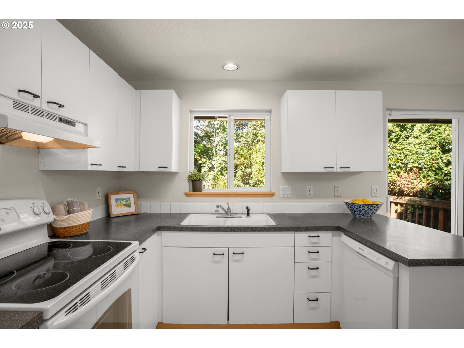 8123 Southwest Hearthside Court Portland, OR 97223 - Photo 8 of 19 a kitchen with kitchen island white cabinets appliances a window and a sink