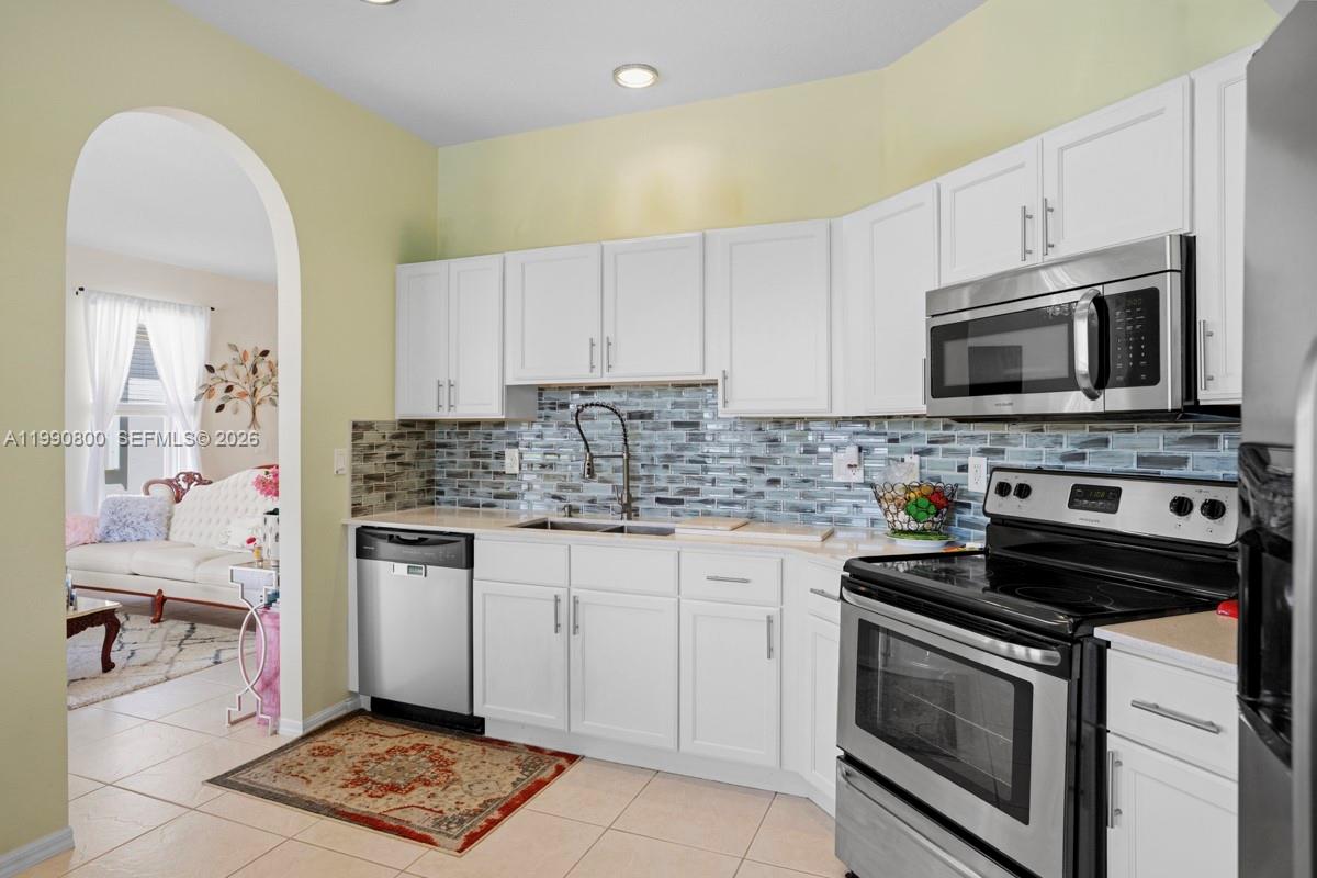 337 Southwest Maclay Way Port St. Lucie, FL 34986 - Photo 7 of 44 a kitchen with stainless steel appliances a stove a sink and a microwave