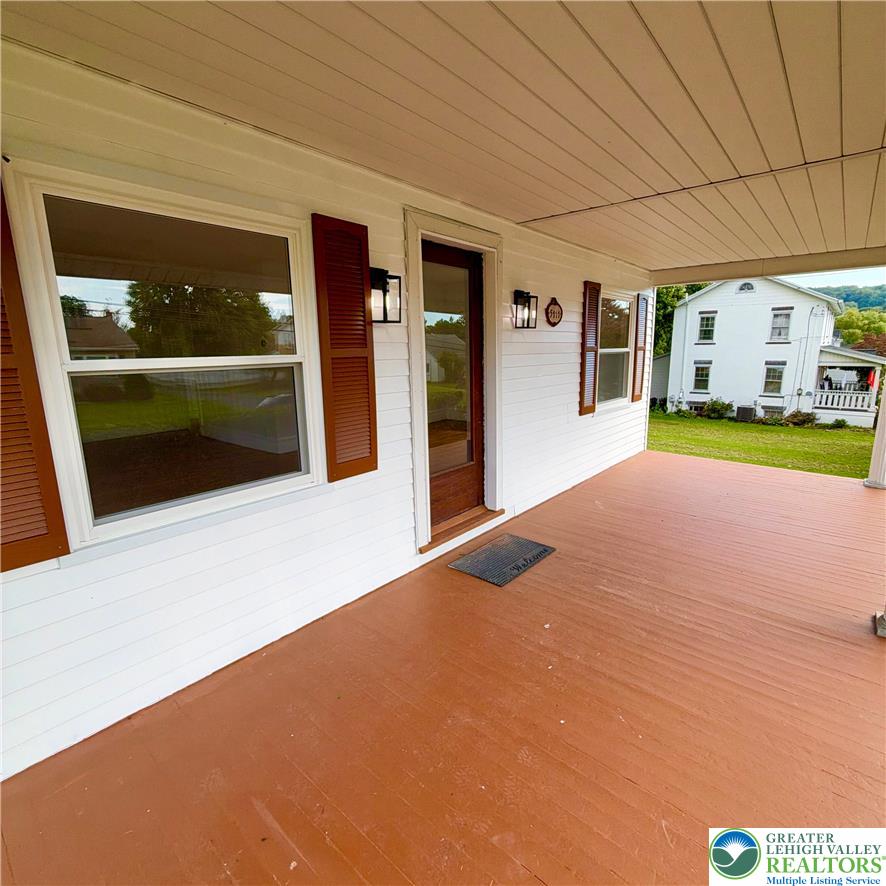 5111 Vera Cruz Road Emmaus, PA 18049 - Photo 5 of 44 A welcoming front porch features classic wood flooring and matching shutters framing wide windows.