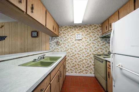 a sink with a granite countertop window and cabinets