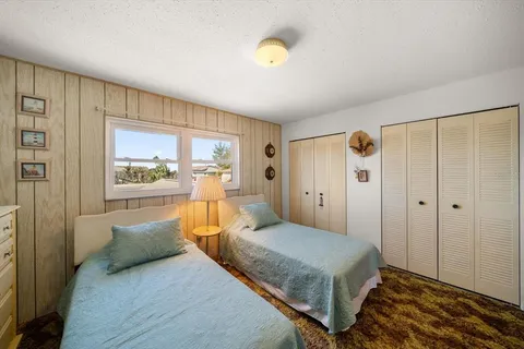 a bedroom with a flat screen tv and a glass door