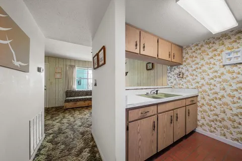 a bathroom with a granite countertop sink a toilet and shower