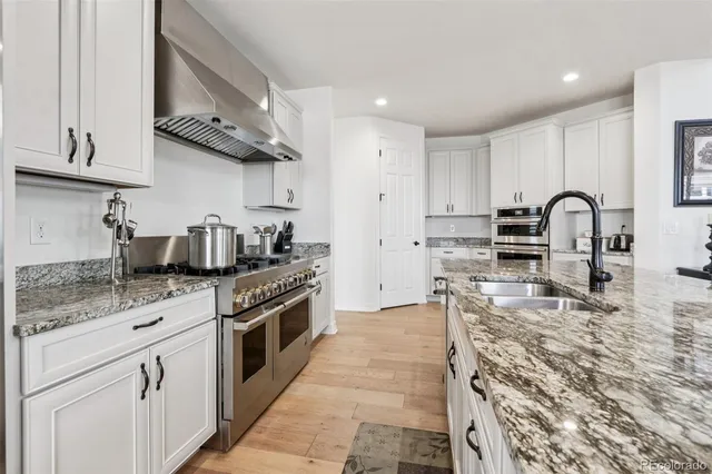 a kitchen with stainless steel appliances granite countertop a stove a sink and a microwave