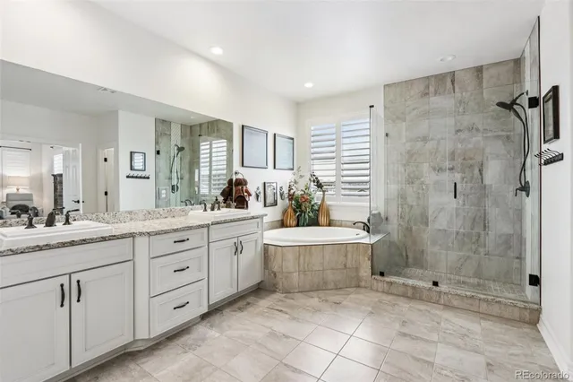 a bathroom with a granite countertop sink a toilet a mirror and shower