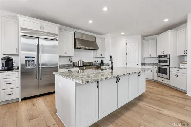 a kitchen with stainless steel appliances granite countertop a stove a sink and a refrigerator