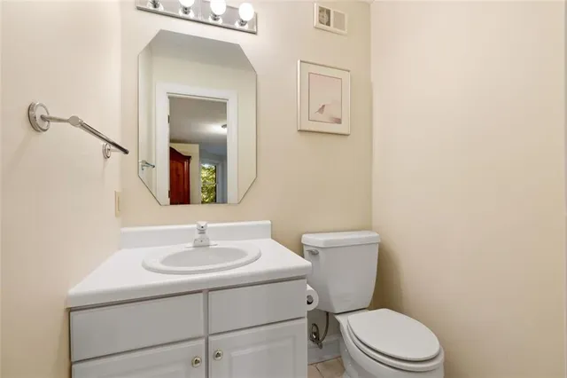 a bathroom with a toilet sink vanity and mirror