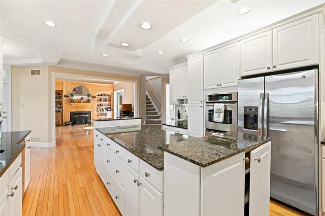 a kitchen with stainless steel appliances granite countertop a sink and a refrigerator