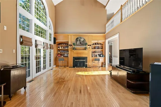 a view of a living room with furniture a fireplace and wooden floor
