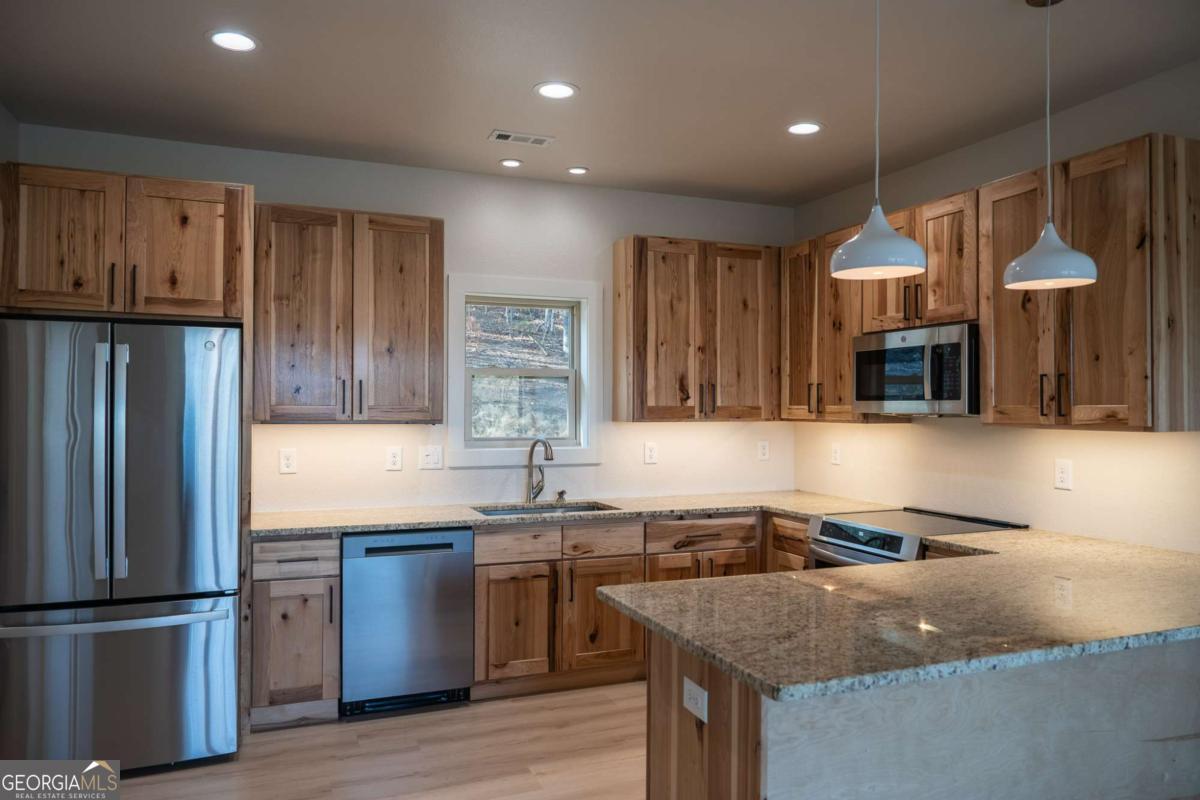 802 Mull Valley Road Morganton, GA 30560 - Photo 49 of 75 a kitchen with granite countertop a sink stainless steel appliances and cabinets